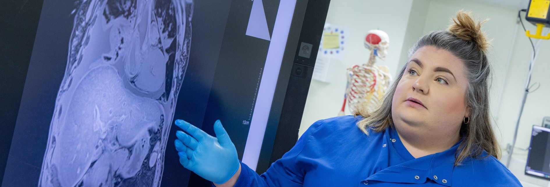 a lecturer pointing to a ct scan